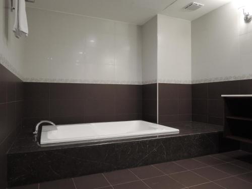 a bath tub sitting on a counter in a bathroom at CHECK inn Taipei Neihu in Taipei