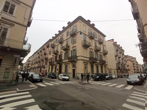 um edifício numa rua com carros estacionados na rua em ArtDecò Rooms Turin em Turim