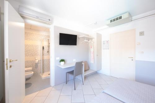 a white bathroom with a desk and a toilet at Hotel Madison in Lido di Jesolo