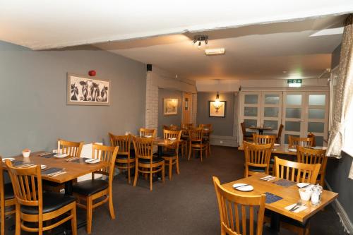 a dining room with wooden tables and chairs at The Finch Hatton Arms in Sleaford