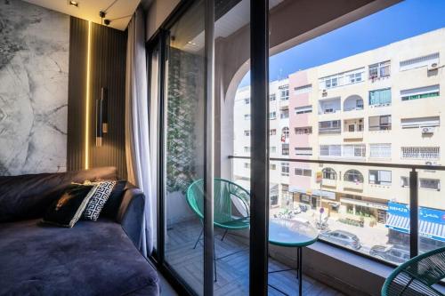 a living room with a couch and a large window at Metropolitan 06-Two Bedrooms - Cavalli Luxury Flat in Casablanca