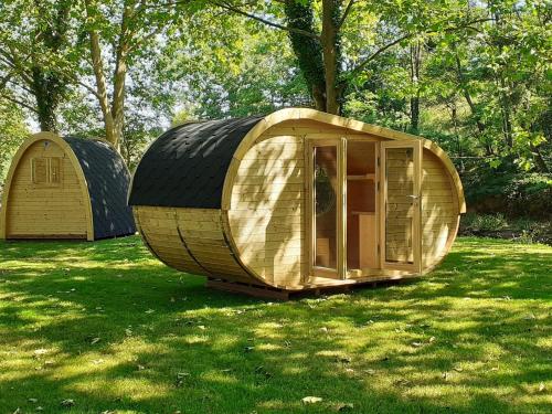 a couple of small wooden houses sitting in the grass at Camping de la Bageasse in Brioude
