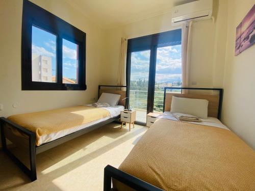 2 camas en una habitación con ventana grande en Sea view Apartment 5 with roof top terrace, Almyrida, en Almyrida