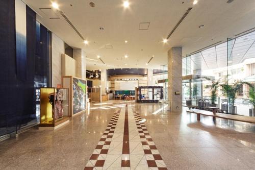 een lobby met een geruite vloer in een gebouw bij Awa Kanko Hotel in Tokushima