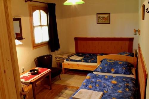 a bedroom with two beds and a table and a desk at Anna Lak in Magyarszombatfa
