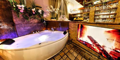 uma grande banheira num quarto com flores em BIRDIE Pension & Wellness em Pardubice