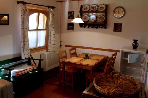 una stanza con un tavolo e delle sedie e un orologio sul muro di Anna Lak a Magyarszombatfa