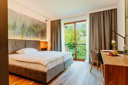 AltlengbachにあるSeminarhotel Lengbachhof GmbHのベッド、デスク、デスクが備わるホテルルームです。