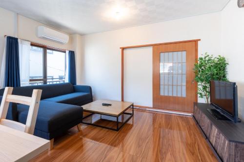 sala de estar con sofá y TV en 平井戸建, en Tokio