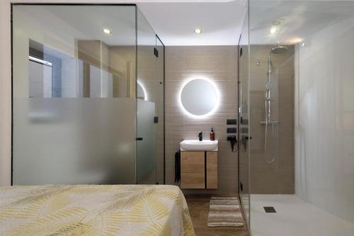 a bathroom with a glass shower and a sink at Casa SanPau in Granada
