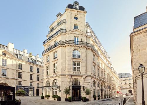 a tall white building with a clock tower on a street at Grand Hôtel Du Palais Royal in Paris