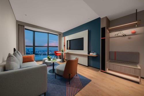 a living room with a couch and a tv at Holiday Inn Express Shantou Chenghai in Shantou