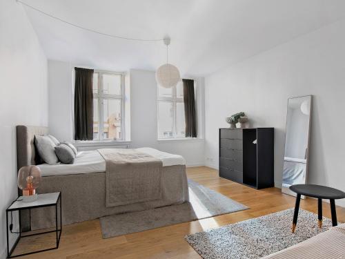 een witte woonkamer met een bed en een tafel bij Sanders Leaves - Charming Three-Bedroom Apartment In Downtown Copenhagen in Kopenhagen