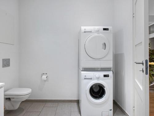 uma casa de banho branca com uma máquina de lavar roupa e um WC em Sanders Leaves - Charming Three-Bedroom Apartment In Downtown Copenhagen em Copenhaga