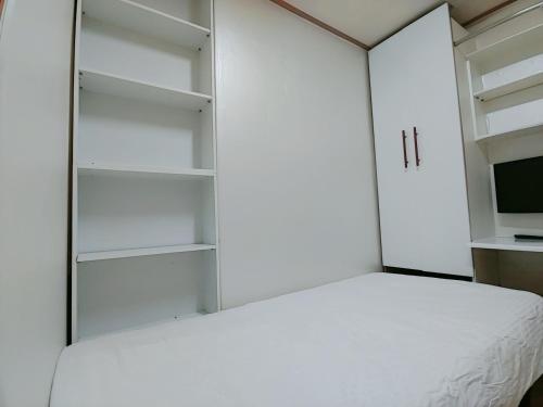 a bedroom with a white bed and a tv at Full house in Seoul
