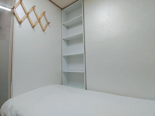 a bedroom with a white bed and a mirror at Full house in Seoul