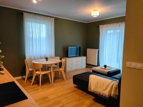 uma pequena sala de estar com uma mesa e um sofá em Apartament Margarita em Kudowa-Zdrój