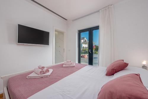 ein Schlafzimmer mit einem großen Bett mit zwei Handtüchern darauf in der Unterkunft Vila Coratina ZadarVillas in Jakišnica