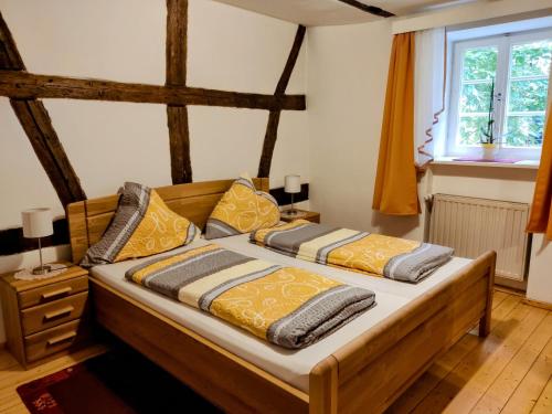 ein Schlafzimmer mit einem Bett mit zwei Kissen darauf in der Unterkunft Pension Pastoriushaus in Bad Windsheim