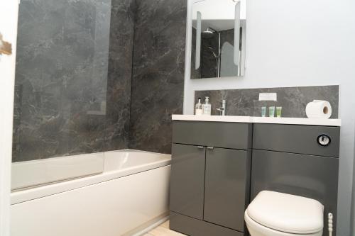 a bathroom with a sink and a tub and a toilet at The Finch Hatton Arms in Sleaford