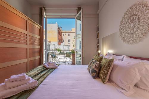 - une chambre avec un grand lit et une grande fenêtre dans l'établissement Oasis Rome Centre Apartment, à Rome