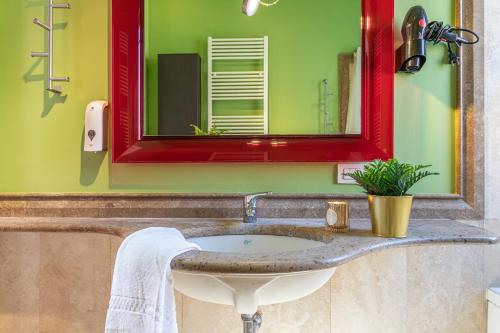 baño con espejo rojo y lavabo en Oasis Rome Centre Apartment, en Roma