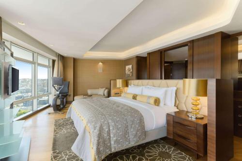 a bedroom with a large bed and a large window at Wyndham Grand Istanbul Europe in Istanbul