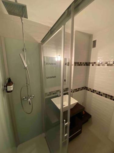 uma casa de banho com uma cabina de duche em vidro e um lavatório. em Le Sun Valley - Vidéoprojecteur et Terrasse Zen em Cannes