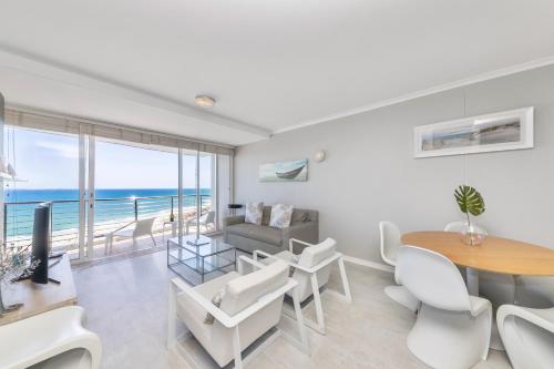 a living room with a dining table and a view of the ocean at Horizon Bay 702 in Bloubergstrand
