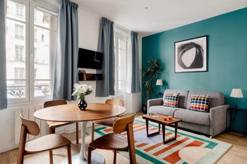 un salon avec une table et un canapé dans l'établissement Edgar Suites Marais - Réaumur, à Paris