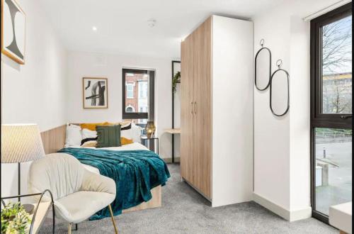 a bedroom with a bed and a chair and a window at Stylish Studio Apartment with Free Parking in Wolverhampton 5min walk to City Centre in Wolverhampton