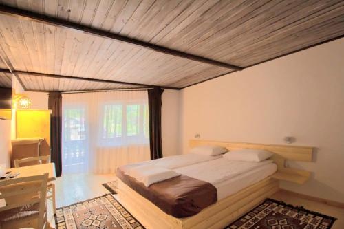 a bedroom with a bed and a wooden ceiling at Fexada Home in Vama