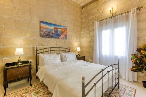 um quarto com uma cama grande e uma janela em Authentic 2BR House of Character with Terrace by 360 Estates em Naxxar