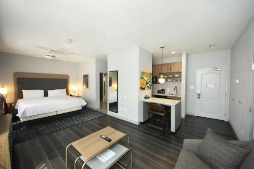 une chambre d'hôtel avec un lit et une cuisine dans l'établissement Homewood Suites Beaumont, à Beaumont