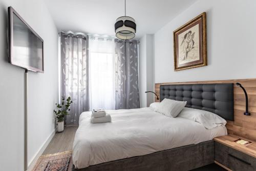 1 dormitorio con 1 cama grande y TV en Xirimiri apartment by People Rentals en Bilbao