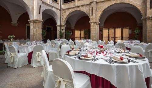 a banquet hall with white tables and chairs at Izan Trujillo in Trujillo