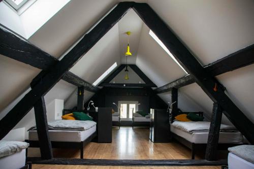 a attic room with two beds and a window at Sax Pub Hostel Ljubljana in Ljubljana