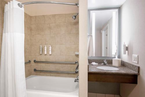 a bathroom with a tub and a sink at Hilton Garden Inn Cleveland Downtown in Cleveland