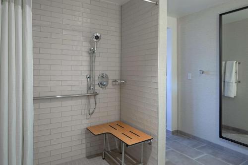 a shower with a wooden bench in a bathroom at DoubleTree Suites by Hilton Orlando at Disney Springs in Orlando