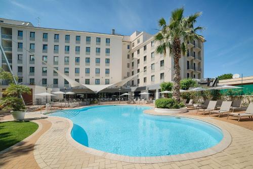 a large swimming pool in front of a hotel at NH Palermo in Palermo
