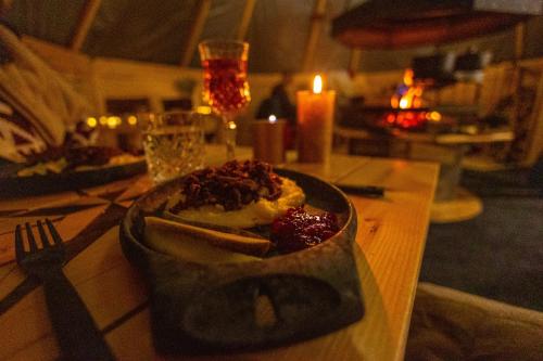 a plate of food on a table with a candle at Skyfire Village Igloos in Rovaniemi