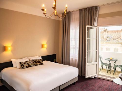 バイヨンヌにあるオテル メルキュール バイヨンヌ サントル ル グランド ホテルのベッドルーム1室(ベッド1台、テーブル、窓付)