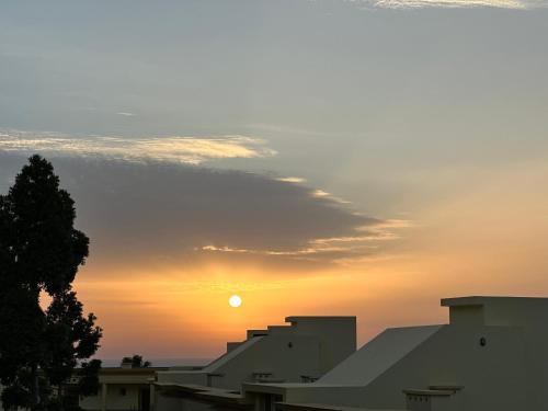 a sunset over a city with the sun in the sky at Tropical Garden in Caniço