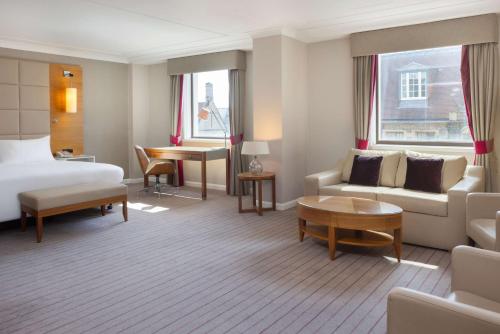 a hotel room with a bed and a couch and a table at Hilton Cambridge City Centre in Cambridge