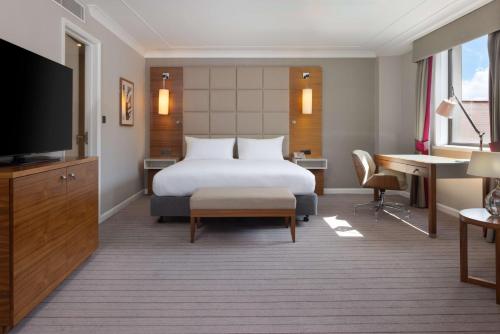 a hotel room with a bed and a desk at Hilton Cambridge City Centre in Cambridge
