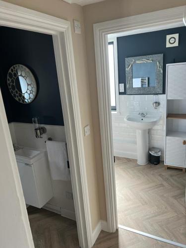 a bathroom with a sink and a toilet and a mirror at Divers Cottage - Central Whitstable in Whitstable