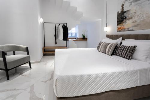 a white bedroom with a bed and a chair at Maison 36 Villa in the center of Psyri in Athens