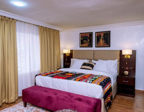 1 dormitorio con cama grande y ventana grande en No.8 Boutique Hotel, en Ilorin