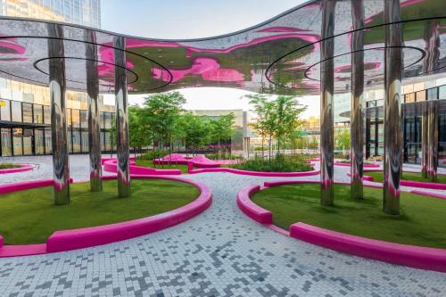 Gebäude mit rosa Bänken und Bäumen in der Unterkunft Park Inn by Radisson Amsterdam City West in Amsterdam