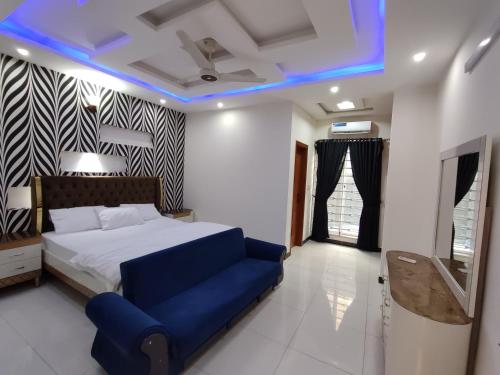 Luxury Holiday Home in Islamabad في اسلام اباد: غرفة نوم بسرير واضاءة زرقاء